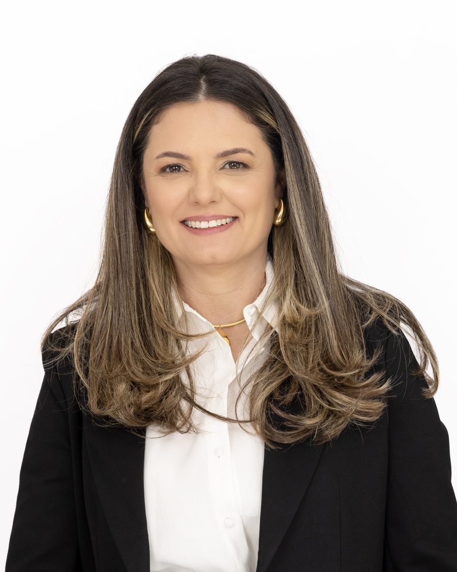 Portrait of a professional in a white shirt and black blazer with a calm confident smile.